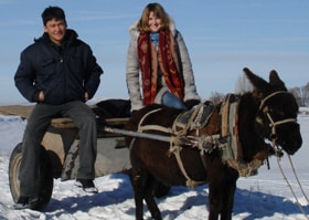 Genna and Rakhat pictured on a traditional donkey cart in winter